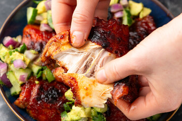Lemon and tomato paste glazed Mediterranean style chicken thighs served with avocado and cucumber salsa, low carb keto meal concept