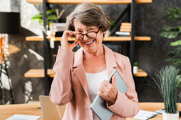 Cheerful caucasian senior manager businesswoman teacher hr ceo with digital tablet looking at the camera in office. Successful teacher lecturer portrait