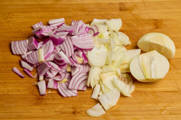 chopped red and yellow onions on a wooden board