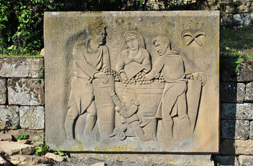 Close up of Carved Stone Panel with Figures in Old Wall of German Vineyard
