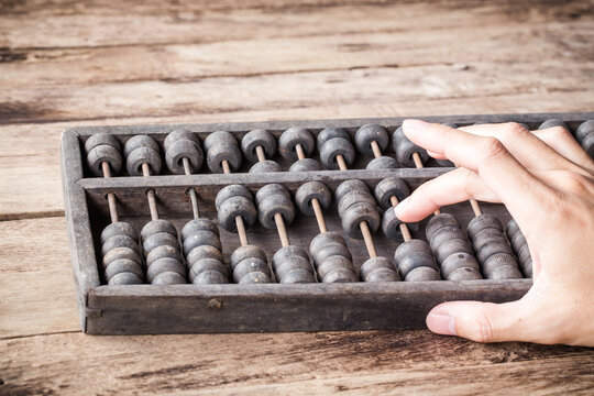 Vintage tone of Man's hands accounting with old abacus and hold electronic calculator. picture financial concept design.