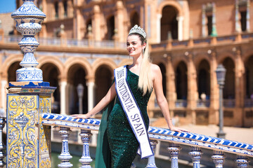 Beautiful young woman winner of a beauty pageant dressed in a green sequined dress and wearing a...