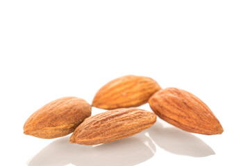 Several roasted almonds, macro, isolated on white background.