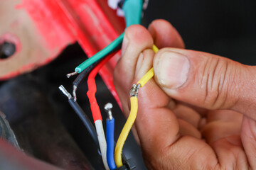 selective focus wires in the hand of a car mechanic Practicing repairs to the ATV's electrical system. Wires of various colors help you know the direction of your car's electrical system.