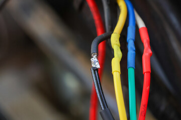 selective focus wires in the hand of a car mechanic Practicing repairs to the ATV's electrical...