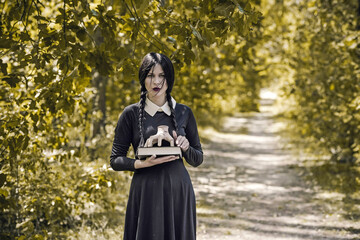 Young goth girl in black dress with white collar. Trend on a gothic style. Halloween look or masquerade