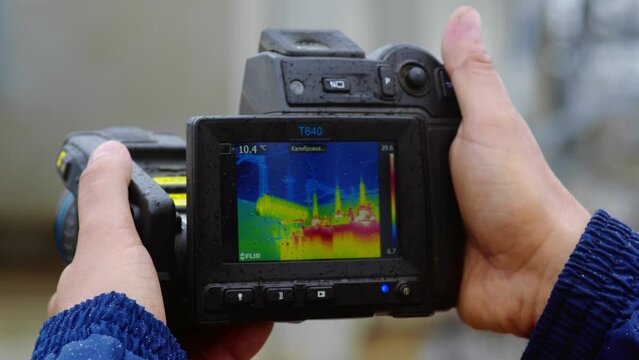A worker conducts an inspection using a thermal imaging camera