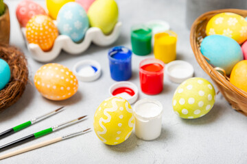 Easter egg painting at the kitchen table.Happy Easter celebration concept.Colorful Easter eggs with different patterns.Paints,decorations for coloring eggs for holiday.Creative background.Copy space