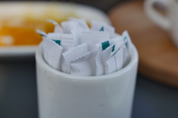 white sugar in a paper packet on table 