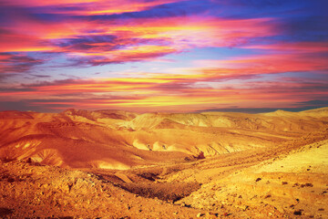 Fototapeta na wymiar Mountainous desert with colorful cloudy sky. Judean desert in the evening