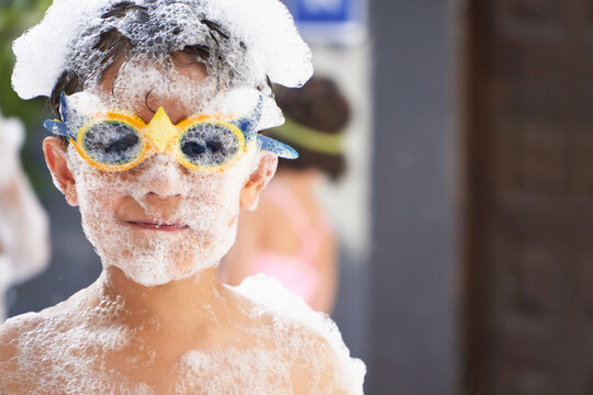 Joyful boy covered in foam at party