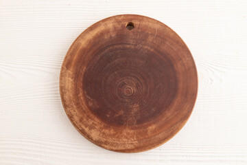 Empty round wooden cutting board on white wooden. Top view