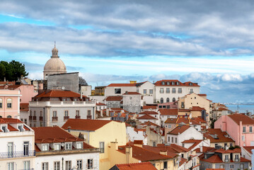 Fototapeta na wymiar Rooftops of and skyline of a Lisbon, Portugal neighborhood overlooking the Tagus River on a cloudy day