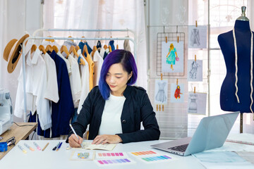 Fashionable freelance dressmaker is designing on new dress by drawing illustrator while working in artistic workshop studio for fashion design and clothing business industry