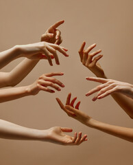 Female arms reaching to each other demonstrating sensitive and tenderness against sandy color...