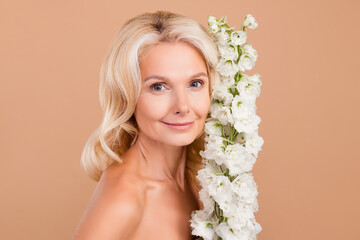 Photo of lovely pretty cute retired woman fresh summer flowers silky soft skin peeling procedure isolated on beige color background