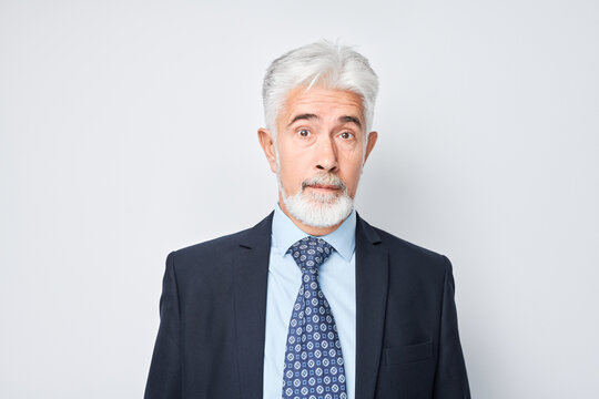 Portrait of a mature businessman with gray hair looking skeptical, isolated on a white background.