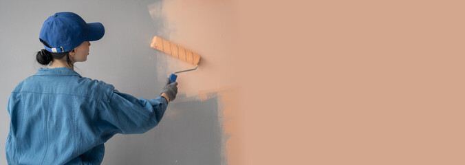 Woman painting house room with paint roller. House painting and renovation business concept. - obrazy, fototapety, plakaty