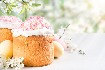 Traditional Easter cake with white swiss meringue and pink sweet decoration and colorful painted...