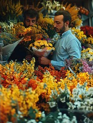 A man is looking at flowers in a market