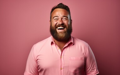 Obraz premium A man with a beard is smiling and wearing a pink shirt