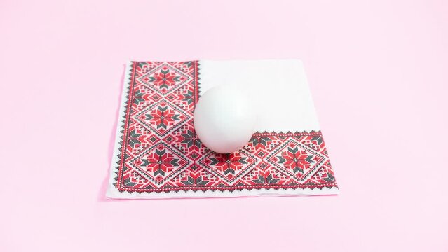 Preparing white eggs for Easter using decoupage technique using napkins. Pink background. Copy space. Looping stop motion animation.