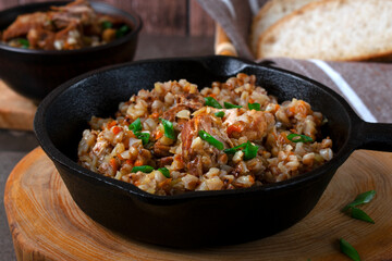 Meat with buckwheat served in the cast iron pan. Nutritious meal for lunch or dinner