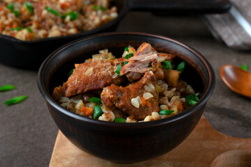 Meat with buckwheat served in a brown bowl. Nutritious meal for lunch or dinner