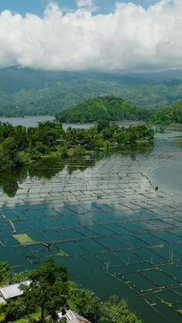 Aerial view of fish farm in Lake Sebu and rainforest, green trees. Mindanao, Philippines. Summer and travel destinations. Vertical view.