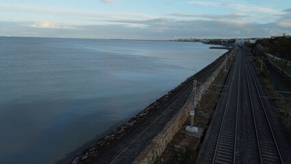 a train traveling down train tracks next to the Irish sea, Blackrock, Dublin, Ireland