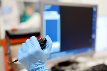 Radiologist is going to take X ray of patient in X-ray room of modern clinic. Close up photo of doctor hand presses button for execute of medical examination
