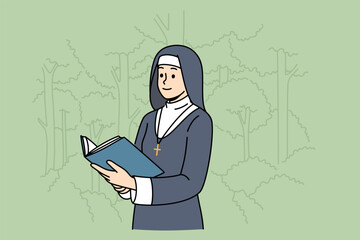 Woman nun with holy book stands in park among trees, dressed in cassock for religious service in temple. Nun studies sacred scriptures and prayers during breaks between prayer services in cathedral - obrazy, fototapety, plakaty