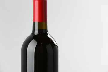 Bottle of expensive red wine on light background, closeup. Space for text