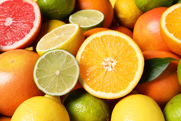Different fresh citrus fruits as background, closeup