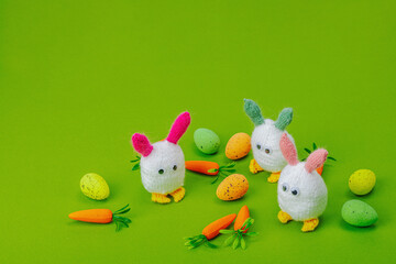 Handmade Easter concept. Knitted bunnies with traditional decoration. Festive symbols, greeting card