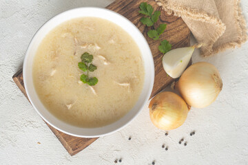 Chikhirtma - Georgian traditional chicken soup in a white plate and ingredients, flat lay