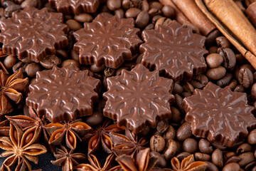 Food background. Coffee beans, cinnamon sticks, anise stars and chocolate candies top view.