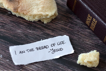 I am the bread of life-Jesus Christ, handwritten text note with holy bible book and cup of wine on...