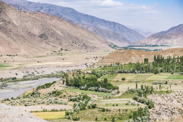 Panorama of mountain ranges and peaks of the Fan Mountains with glaciers, rocks and vegetation in...