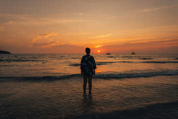 Summer sunset,Woman walking on the beach watching the sunset