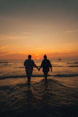 Summer sunset,Couple walking on the beach watching the sunset