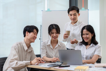 team of Asian businessmen meets to brainstorm ideas about office work management in an office conference room.