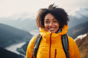 Fototapete Rund A portrait of a beautiful young African American woman relishing a mountain hike, displaying wanderlust and the thrill of mountaineering. © Darya