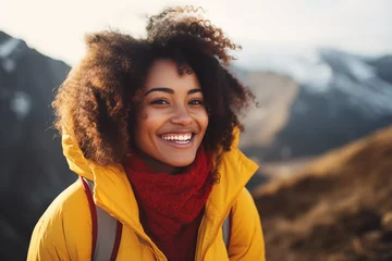 Zelfklevend Fotobehang A portrait of a beautiful young African American woman relishing a mountain hike, displaying wanderlust and the thrill of mountaineering. © Darya