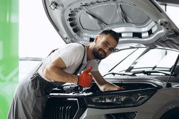 Car mechanic holding wrench for car repair