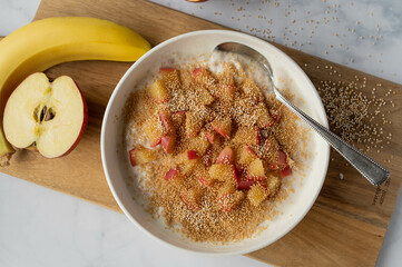 Healthy breakfast with a banana yogurt. Topped with puffed amaranth and cooked apples in a bowl