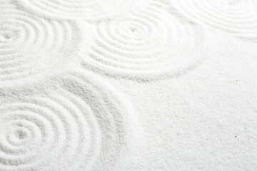 Fototapeta na wymiar Zen rock garden. Circle patterns on white sand, closeup