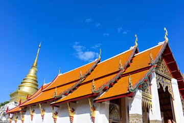 beautiful sanctuary and golden pagoda in ancient buddhist temple on blue sky background ,NAN Province,Thailand