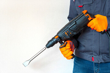 rotary hammer. Hands in protective gloves with  perforator.