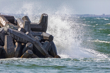 Breakwater and sea spray, Magdalen Islands, Canada. Water crashes against the concrete barrier in...
